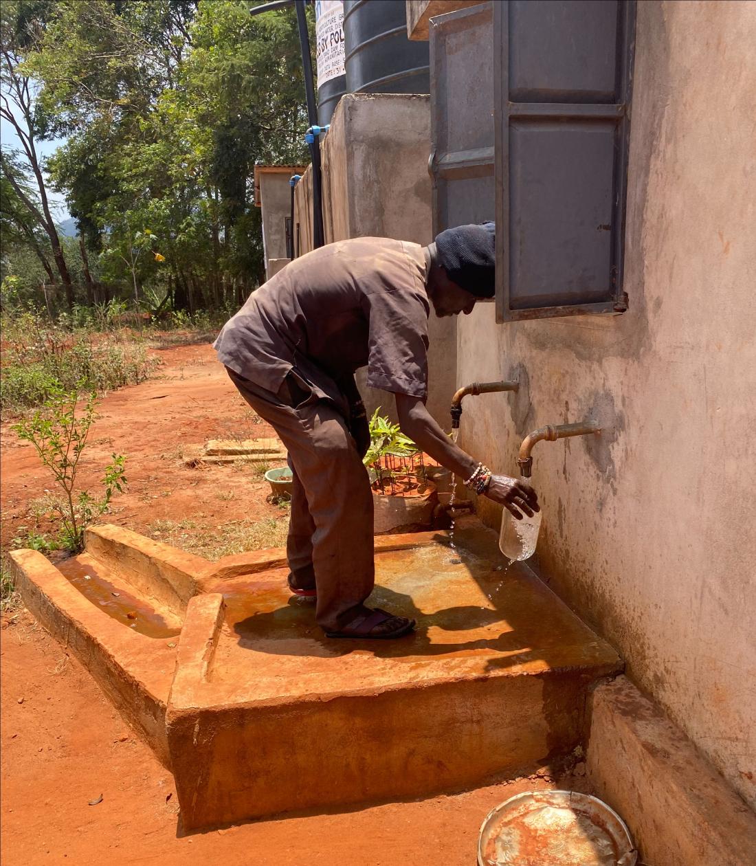 man filling jug from water access point