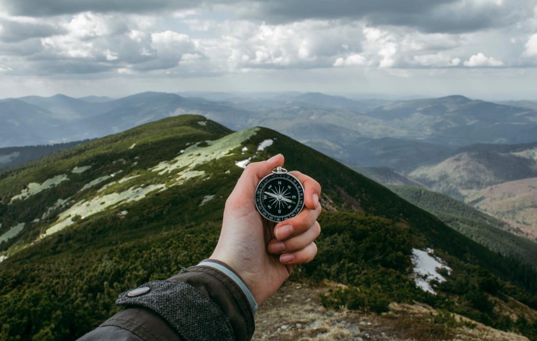 viewing a compass on a mountain top