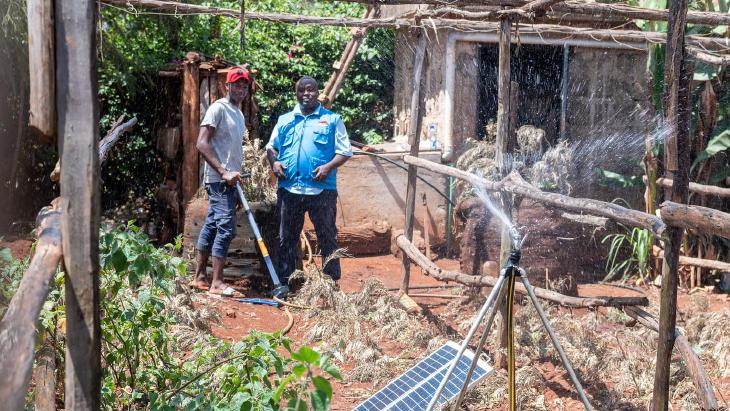 two farmers examining solar powered irrigation system