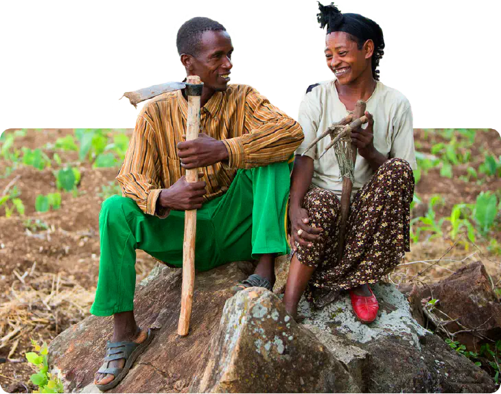 Nuru-supported farmers sitting in a green field in Africa.