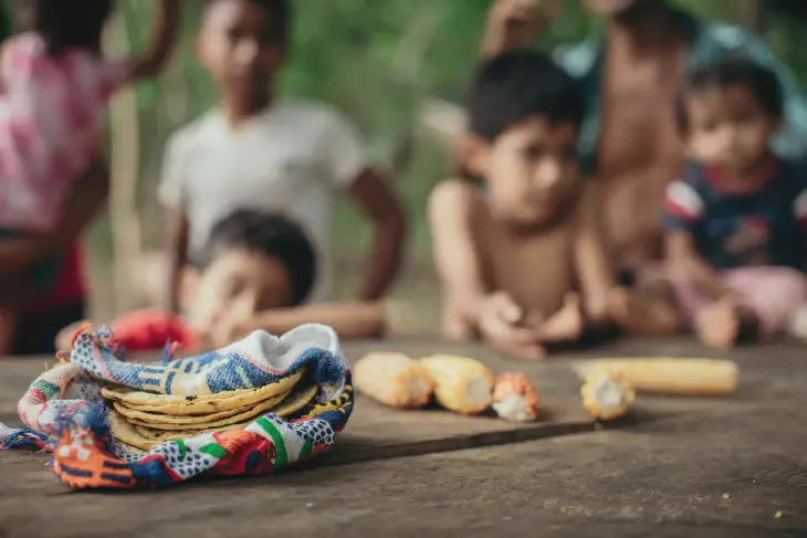 picture of children looking at corn and tortillas