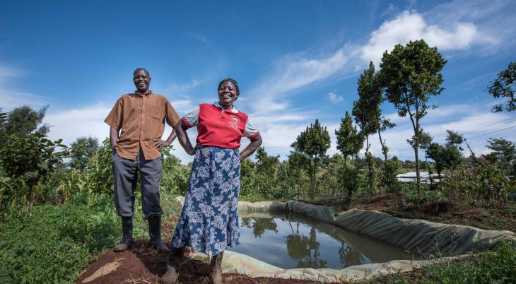 two people standing near water catchment basis